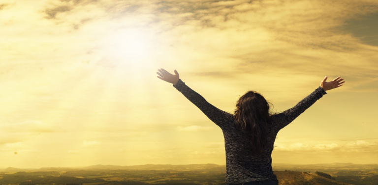 Lady with arms outstreched to sunlight