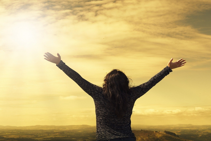 Lady with arms outstreched to sunlight